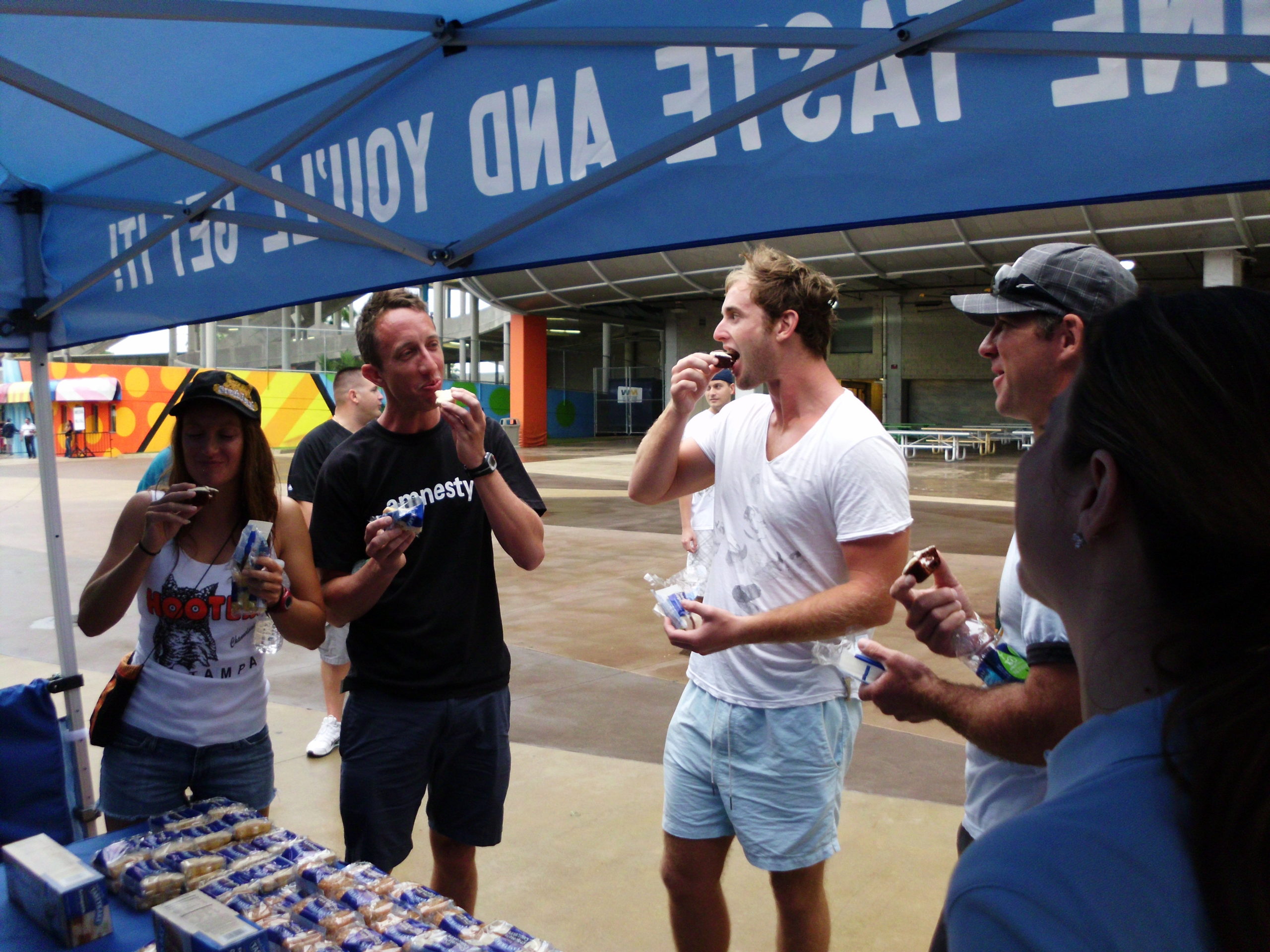 People eating snacks at a blue tent