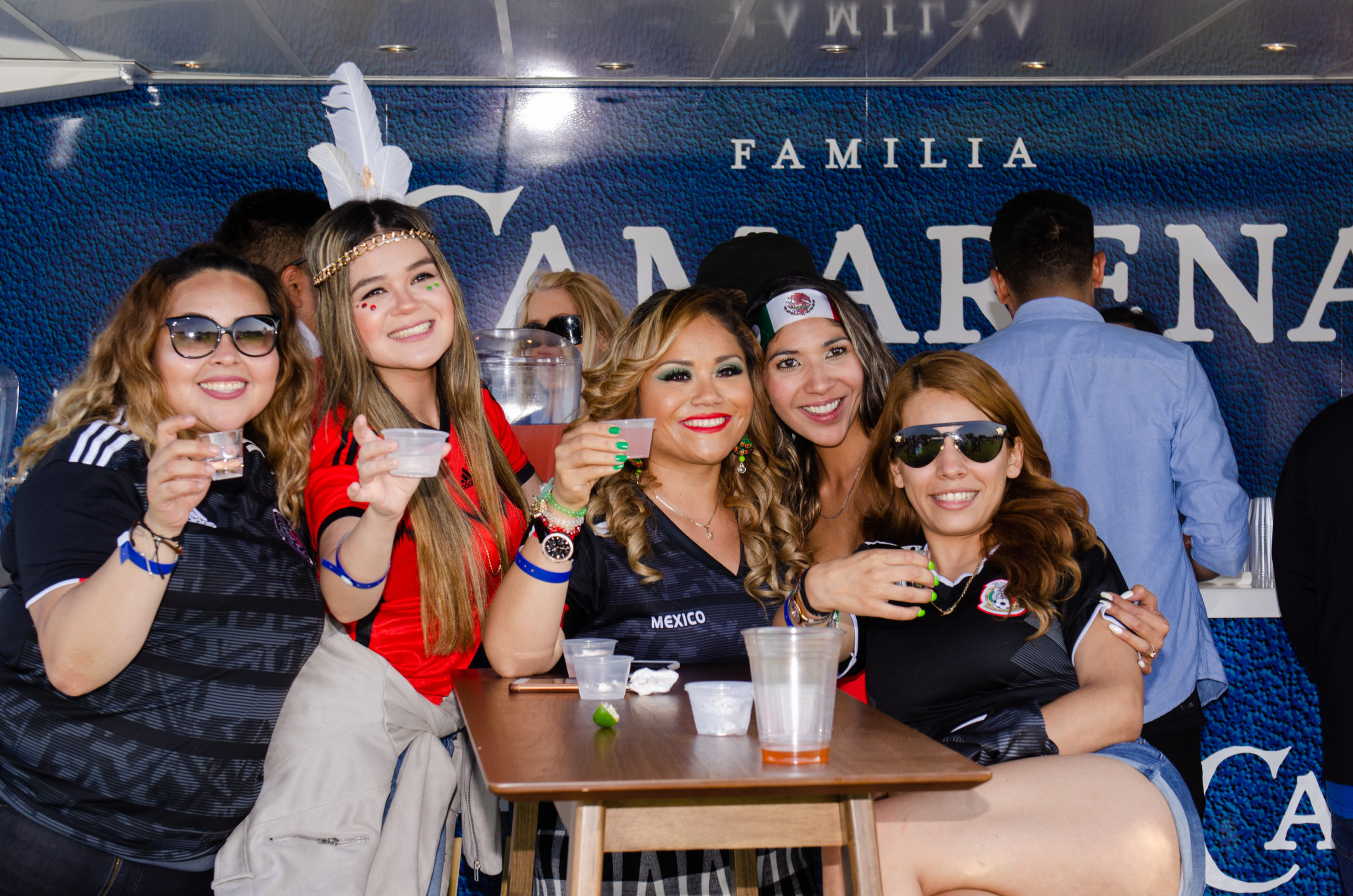 A few women posing with drinks in their hands