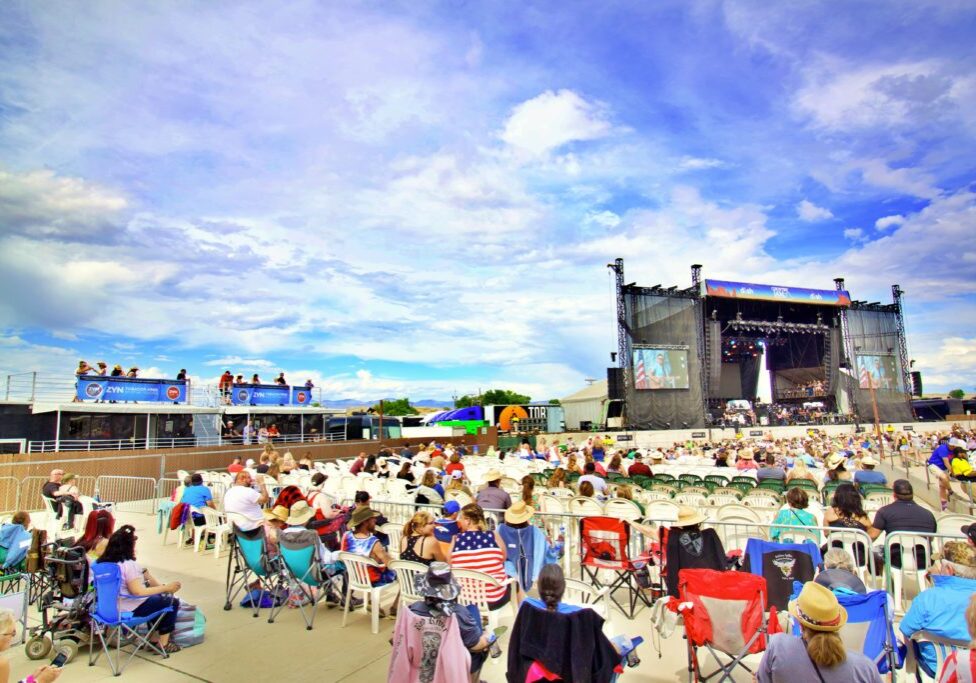 People gathered in an open area in front of a stage